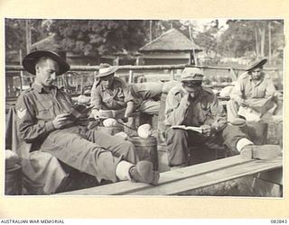 LAE, NEW GUINEA. 1944-11-12. TROOPS AWAITING THE SCREENING OF THE 1944 MELBOURNE CUP ARRANGED BY AUSTRALIAN ARMY AMENITIES SERVICE ATTACHED HQ FIRST ARMY. PETROL DRUMS AND BOXES FORMED MANY OF THE ..