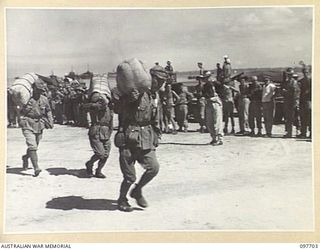 TOROKINA, BOUGAINVILLE. 1945-09-21. JAPANESE TROOPS FROM NAURU ISLAND, WHO ARRIVED AT TOROKINA PER SS RIVER BURDEKIN, CARRYING THEIR VARIED POSSESSIONS FROM THE BARGES TO THE BEACH. THEY ARE ABOUT ..