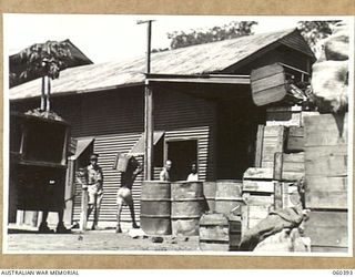 17 MILE, LALOKI RIVER, NEW GUINEA. 1943-11-22. UNLOADING EMPTY BOTTLES AT THE CORDIAL FACTORY ESTABLISHED AND OPERATED BY THE AUSTRALIAN DEFENCE CANTEEN SERVICES ATTACHED TO HEADQUARTERS, NEW ..