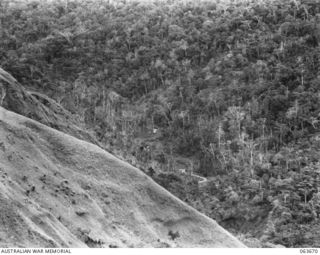 FARIA RIVER, NEW GUINEA. 1944-01-11. LOOKING DOWN ON THE JUNCTION OF THE FARIA RIVER FROM THE PLATEAU. THE JAPANESE ARE DUG IN ON BOTH SIDES OF THE JUNCTION, WHILE ON THIS SIDE OF IT ARE A MORTAR ..