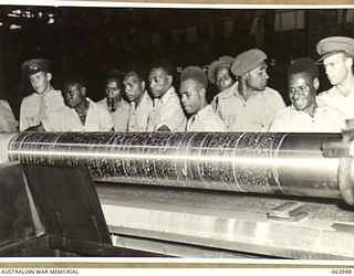 NEWCASTLE, NSW. 1944-01-28. AUSTRALIAN AND NEW GUINEA ADMINISTRATION UNIT NATIVES WATCHING A HEAVY DUTY LATHE IN OPERATION AT THE BROKEN HILL PTY. WORKSHOPS