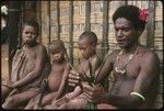 Man performing aringa divination as children look on