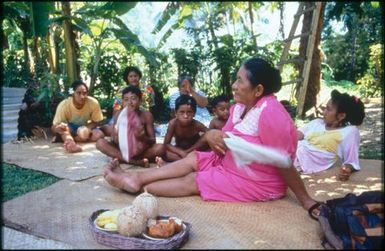 Group sitting on mats under trees