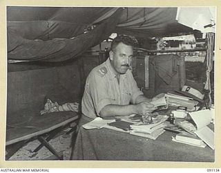 JACQUINOT BAY, NEW BRITAIN. 1945-04-21. MAJOR L.F. DARLING, PERMANENT PRESIDENT COURT MARTIALS, 5 DIVISION, IN HIS OFFICE