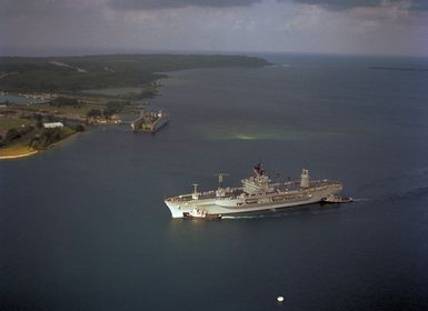 Large harbor tugs maneuver the amphibious command ship USS BLUE RIDGE (LCC 19) into the harbor