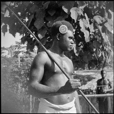 Asavia [?] with a spear over his shoulder and a kapkap in his hair, Rabaul, New Guinea, ca. 1936, 2 / Sarah Chinnery