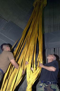 US Air Force (USAF) AIRMAN First Class (A1C) Oscar Hurtado and STAFF Sergeant (SSGT) John Rizzo from the 7th Expeditionary Maintenance Squadron (EMXS), untangle parachute cords to a B-52 Stratofortress bomber drag-chute, at Andersen Air Force Base (AFB), Guam