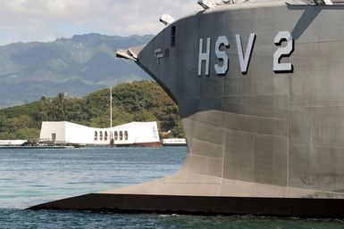 The bow of US Navy (USN) experimental High Speed Vehicle 2 (HSV 2) Swift frames the USS Arizona (BB 39) Memorial while shifting berths at Pearl Harbor, Hawaii (HI). The Swift is taking part in the multi-national maritime Exercise RIM OF THE PACIFIC 2004 (RIMPAC). RIMPAC is the largest international maritime exercise in the waters around the Hawaiian Islands. This years exercise includes seven participating nations: Australia, Canada, Chile, Japan, South Korea, United Kingdom and United States. RIMPAC is intended to enhance the tactical proficiency of participating units in a wide array of combined operations at sea, while enhancing stability in the Pacific Rim region