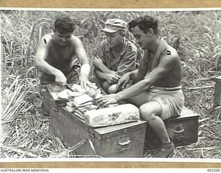 WALINGAI BEACH, NEW GUINEA. 1944-01-02. TROOPS OF THE NO. 27 PLATOON, 2/6TH AUSTRALIAN SUPPLY DEPOT COMPANY, PREPARING HAM SANDWICHES FOR THEIR COMRADES DURING THE HUON PENINSULA CAMPAIGN WATCHED ..