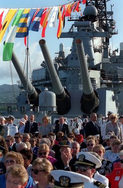 Guests gather near the Mark 7 16-inch 50-caliber guns of the battleship USS MISSOURI (BB-63) as they watch televised events commemorating the 50th anniversary of the Japanese attack on Pearl Harbor. The MISSOURI is visiting Pearl Harbor in honor of the occasion