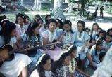 Native women and children playing guitar and singing, Likiep Atoll, August 20, 1949