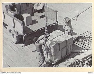 LAE AREA, NEW GUINEA, 1945-07-11. THE MID-YEAR HAMPERS DISTRIBUTED BY THE AUSTRALIAN COMFORTS FUND, LAE DISTRIBUTION CENTRE, ABOUT TO BE LOADED FOR SHIPMENT TO OPEN BAY, NEW BRITAIN