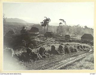 ILOLO, NEW GUINEA, 1944-03-30. THE ADMINISTRATIVE AREA OF THE AUSTRALIAN NEW GUINEA ADMINISTRATIVE UNIT NATIVE LABOUR CAMP VIEWING IMITA RIDGE IN THE LEFT FOREGROUND