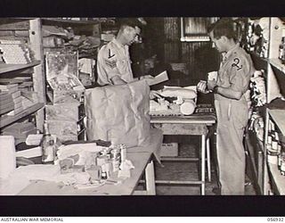 ROCKY CREEK, QLD. 1943-08-25. QX121 SERGEANT F. J. HUGHES (1) AND SX7217 PRIVATE G. H. WINDEBANK (2) OF THE AUSTRALIAN RED CROSS SOCIETY FIELD FORCE BRANCH, PACKING THIRTY POUND PARCELS FOR ..