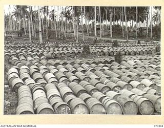 MADANG, NEW GUINEA. 1944-05-18. THOUSANDS OF GALLONS OF MOTOR SPIRIT NEATLY STACKED AT A BULK ISSUE PETROL AND OIL DEPOT OF THE 5TH DIVISION