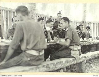 SIAR, NEW GUINEA. 1944-06-20. OFFICERS OF THE 58/59TH INFANTRY BATTALION EATING LUNCH IN THE OFFICER'S MESS. IDENTIFIED PERSONNEL ARE:- NX146381 CAPTAIN H. BEVAN (1); TX4464 LIEUTENANT F.O. SMITH ..