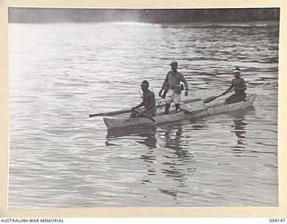 TINIAN, BOUGAINVILLE, 1945-07-18. A CANOE WITH A "BOSS BOY" ABOARD COMES OUT TO GIVE DIRECTIONS TO AN ALLIED INTELLIGENCE BUREAU RESCUE CRAFT WHICH IS PICKING UP TEN NETHERLANDS EAST INDIES ARMY ..