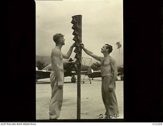 TOROKINA, BOUGAINVILLE ISLAND, SOLOMON ISLANDS. C. 1945-01-25. NOT A NATIVE TOTEM-POLE BUT AN EXHAUST FLAME TRAP FROM A BOOMERANG AIRCRAFT OF NO. 5 (TACTICAL RECONNAISSANCE) SQUADRON RAAF AT PIVA ..