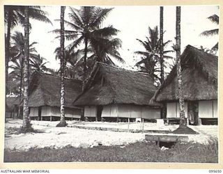 PALMALMAL, JACQUINOT BAY, NEW BRITAIN. 1945-09-01. TRIM NATIVE BUILT HUTS THATCHED WITH SAC-SAC WHICH HOUSE FIRST ARMY PROVOST CORPS PERSONNEL IN 5 BASE SUB-AREA