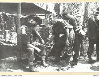 IDAKAIBUL, NEW GUINEA. 1945-01-23. TROOPS OF THE 6TH DIVISION PAUSE FOR A CUP OF TEA AT THE SALVATION ARMY STALL WHILE ACCOMPANYING THEIR GENERAL OFFICER COMMANDING ON THE MARCH TO MALIN AND RETURN ..