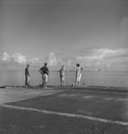 Four people looking at a Catalina flying boat at Tahiti