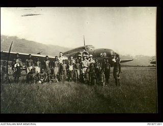 Garaina, New Guinea. ?1943. Crew of an Avro Anson aircraft of No. 33 Squadron RAAF in front of their aircraft (59) with a group of local native men and boys. The crew were delivering food and ..