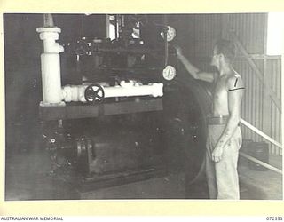 PORT MORESBY, NEW GUINEA. 1944-04-18. TX8399 SAPPER L.J. RANDALL, 8TH ARMY TROOPS COMPANY, ROYAL AUSTRALIAN ENGINEERS ADJUSTS A DELIVERY VALVE ON A COMPRESSOR IN THE FREEZING PLANT AT NO. 2 COLD ..