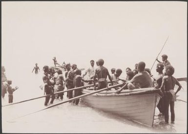 Villagers greeting boy in boat returning from Norfolk Island via the Southern Cross, Vanikolo, Santa Cruz Islands, 1906 / J.W. Beattie