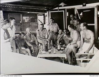 Madang, New Guinea, 1945-12. In the Officers' Mess at Headquarters, RAAF Northern Command (NORCOM), a group of RAAF officers enjoys an informal Sunday morning glass of beer with the unit's ..