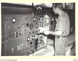 LAE, NEW GUINEA. 1945-03-11. VX128263 SIGNALLER R. DAY, 18TH WIRELESS SECTION (HEAVY), 19TH LINES OF COMMUNICATION SIGNALS WORKING ON A WS133 TRANSMITTER AT THE 1ST ARMY TRANSMITTER SITE, BUSU