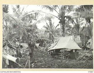 JACQUINOT BAY, NEW BRITAIN. 1944-11-07. A TEMPORARY CAMP SITE SET UP IN THE JUNGLE BY MEMBERS OF C COMPANY 14/32ND INFANTRY BATTALION. IDENTIFIED PERSONNEL ARE: VX140354 PRIVATE L.P. SINCLAIR (1), ..