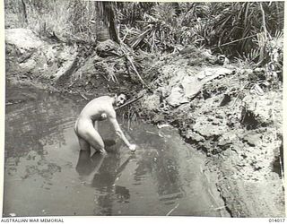1943-01-08. PTE. SAL. CORONA OF CALIFORNIA USES A BOMB CRATER AS A SWIMMING POOL. THE CRATER IS ON THE MAIN STRIP AT BUNA AND, WHEN THE PHOTO WAS TAKEN, JAPANESE WERE ONLY 100 YARDS AWAY. (NEGATIVE ..