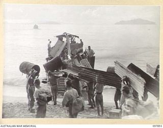 KAHILI, BOUGAINVILLE. 1945-09-30. JAPANESE TROOPS LOADING CORRUGATED IRON ONTO A BARGE FOR USE IN THE CONSTRUCTION OF THE CONCENTRATION AREA ON FAURO ISLAND. THE SURRENDER COMMISSION FROM ..