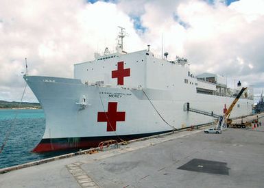 A port bow view of the US Navy (USN) Military Sealift Command (MSC), Hospital Ship, USNS MERCY (T-AH 19), moored to the pier at Apra Harbor, Naval Station Guam, after arriving for a one-day stop to give the crew a break and pick up Sailors assigned to Naval Mobile Construction Battalion 40 (NMCB-40). The USNS MERCY is currently conducting a scheduled five-month deployment to deliver aid and humanitarian assistance to the Pacific Islands and Southeast Asia