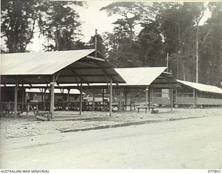 LAE BASE AREA, NEW GUINEA. 1944-12-27. MEN'S MESS (FOREGROUND) AND SERGEANTS MESS (RIGHT BACKGROUND) IN THE CAMP AREA OF THE 13TH WORKSHOPS AND PARK COMPANY