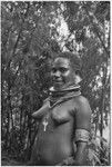 Courtship: smiling adolescent girl wears shell valuables, trade beads, and other finery (including keys on ring), ready for courtship event