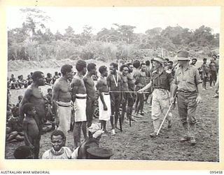 KIARIVU, NEW GUINEA, 1945-08-17. CAPTAIN R.R. COLE, ASSISTANT DISTRICT OFFICER, AUSTRALIAN NEW GUINEA ADMINISTRATIVE UNIT, MAPRIK, NEW GUINEA, ACCOMPANIED BY WARRANT OFFICER 2 T. HEALEY, HIS 2 IN ..