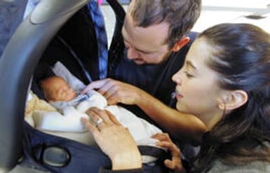 Denver residents Mike and Carie Fay care for baby Josiah as they wait for their luggage at DIA Wednesday afternoon January 18, 2006. They returned home from Hawaii today with Mike's sister, Sarah's, newborn baby, Josiah. Sarah was beaten nearly to death b