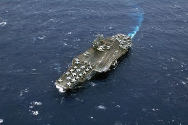 Aerial view of the US Navy (USN) Aircraft Carrier, USS KITTY HAWK (CV 63) maneuvering as it prepares to enter Apra Harbor, Guam for a scheduled port visit