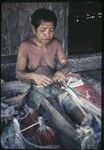 Weaving: woman makes skirt out of banana leaf fibers, some dyed red