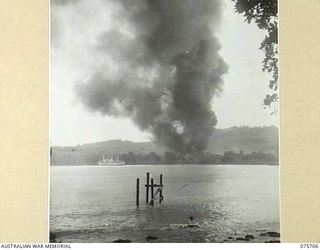 LANGEMAK BAY, NEW GUINEA. 1944-08-21. DENSE COUDS OF BLACK SMOKE RISING FROM AN AMERICAN AVIATION FUEL DUMP BURNING FIERCELY