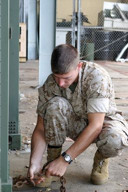 US Marine Corps (USMC) Lance Corporal (LCPL) Johnson, assigned to Combat Service Support Group 3 (CSSG-3), Marine Forces Pacific (MARFORPAC), attaches a tow chain to a Combat Camera and Printing (CC&P) portable transport van in order to move it to a staging area at Camp H.M. Smith, Hawaii (HI), as the Unit prepares for deployment to Iraq, in support of Operation IRAQI FREEDOM