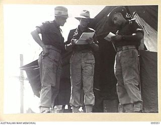 CAPE WOM, WEWAK AREA, NEW GUINEA, 1945-08-24. MAJOR F.E. DAVIS, COMMANDING OFFICER 2/119 BRIGADE WORKSHOP CORPS OF AUSTRALIAN ELECTRICAL AND MECHANICAL ENGINEERS (2), ISSUING THE DAY'S ORDERS TO ..