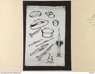 LAE AREA, NEW GUINEA, 1945-08-03. A "PIDGIN" ENGLISH CHART USED FOR THE INSTRUCTION OF NATIVE REGIMENTAL AID POST ORDERLIES. THE PHOTOGRAPH WAS MADE AT THE REQUEST OF HEADQUARTERS AUSTRALIAN NEW ..