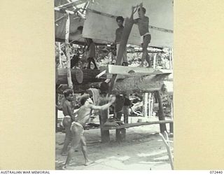 KOKODA, NEW GUINEA. 1944-04-13. NATIVE PRISONERS UNDER THE CONTROL OF THE SUB DISTRICT OFFICE, AUSTRALIAN NEW GUINEA ADMINISTRATIVE UNIT AT A PRISON STATION USING PIT SAWS TO CUT TIMBER FOR ..