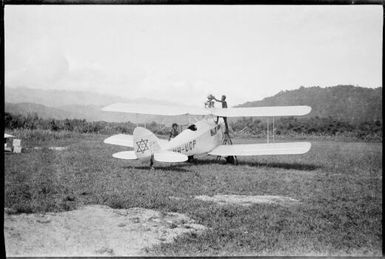 Refuelling De Havilland Moth VH-UQP, operated by Carpenters, Salamaua, New Guinea, ca. 1936 / Sarah Chinnery