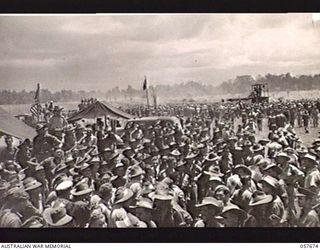 SOPUTA, NEW GUINEA. 1943-10-09. GENERAL VIEW OF THE CROWD ON THE COURSE, SHOWING AUSTRALIAN AND AMERICAN FLAGS AT THE RACE MEETING CONDUCTED BY THE 11TH AUSTRALIAN DIVISION. THE "RACEHORSES" WERE ..