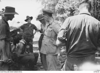 TSIMBA AREA, BOUGAINVILLE ISLAND. 1945-02-06. VX13 LIEUTENANT- GENERAL S.G. SAVIGE, CB, CBE, DSO, MC, ED, GENERAL OFFICER COMMANDING, 2ND AUSTRALIAN CORPS (1) CHATTING WITH WOUNDED SOLDIERS OF THE ..