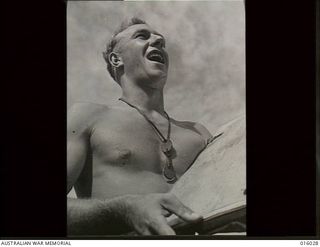 NEW GUINEA. UPPER RAMU VALLEY ADVANCE. 30 OCTOBER 1943. AN AUSTRALIAN BATTERY IN THE URIA VALLEY COVERS THE JAPANESE ROAD TO MADANG. A BARE-CHESTED LIEUTENANT A. EVANS OF CARNEGIE, VIC, GIVES THE ..