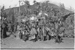 Pig festival, pig sacrifice, Kwiop: inside ritual fence, men prepare to distribute bundles of salted pork (right) to allies